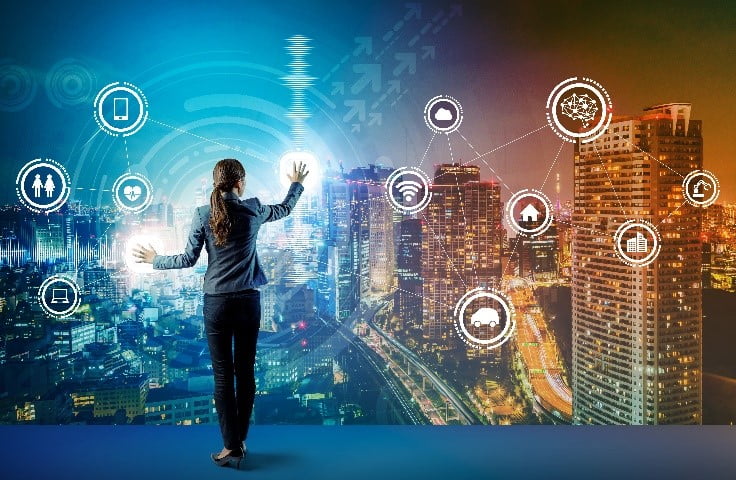 Woman touching digital screen in front of skyline