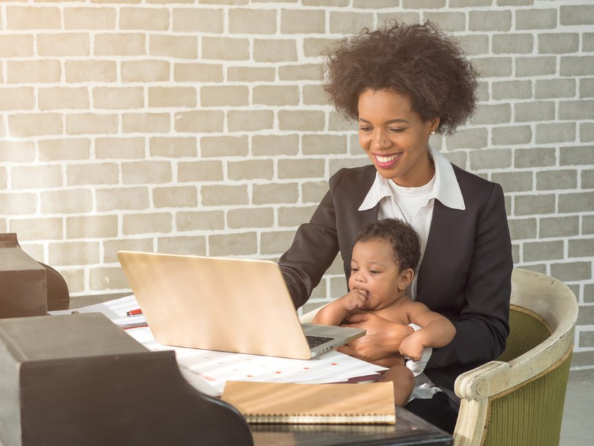 Mother Working from Home Holding her Baby